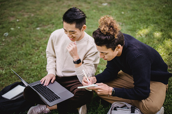 students outside grass laptop studing